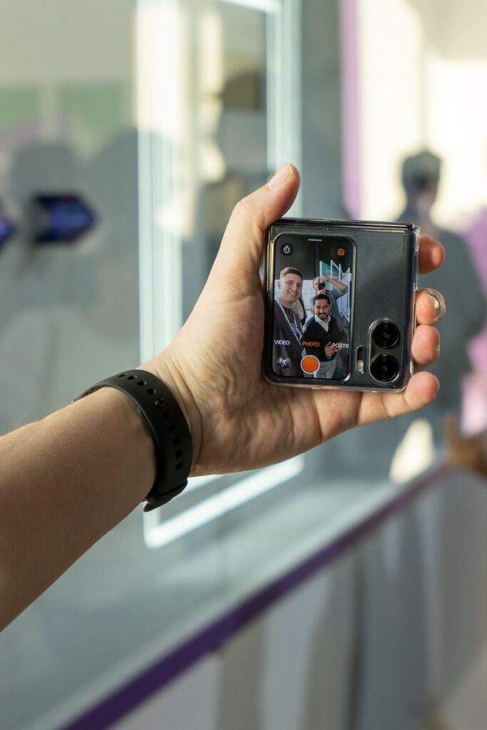 Wyciągnięta ręka podczas robienia selfie złożonym telefonem oppo