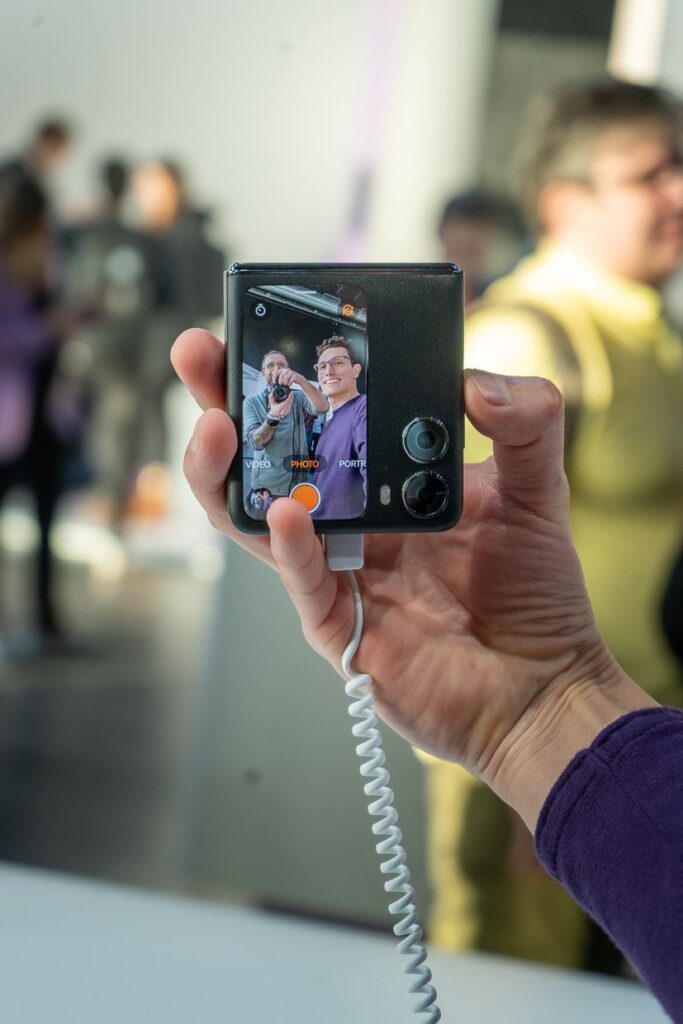 fotograf na małym ekranie telefonu podczas robienia selfie złożonym urządzeniem