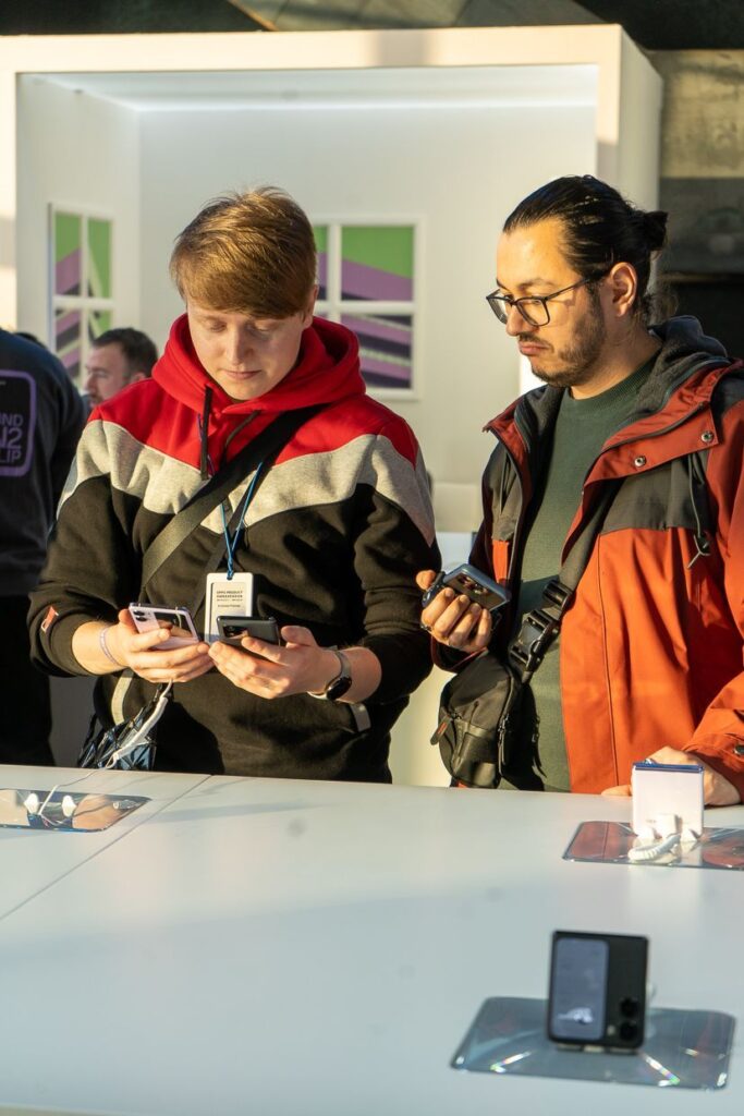 dwaj Ambasadorzy oppo trzymający telefony w dłoniach i dyskutujących