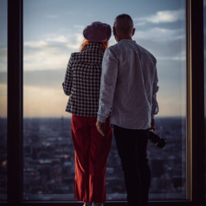 para fotografów spoglądających na Londyn z wieżowca