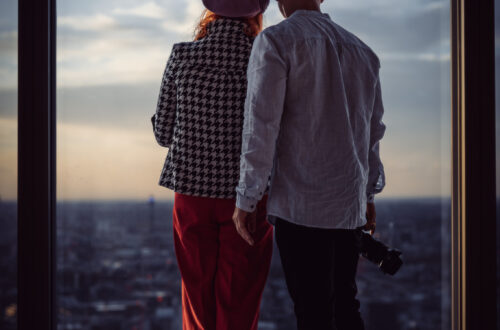 para fotografów spoglądających na Londyn z wieżowca