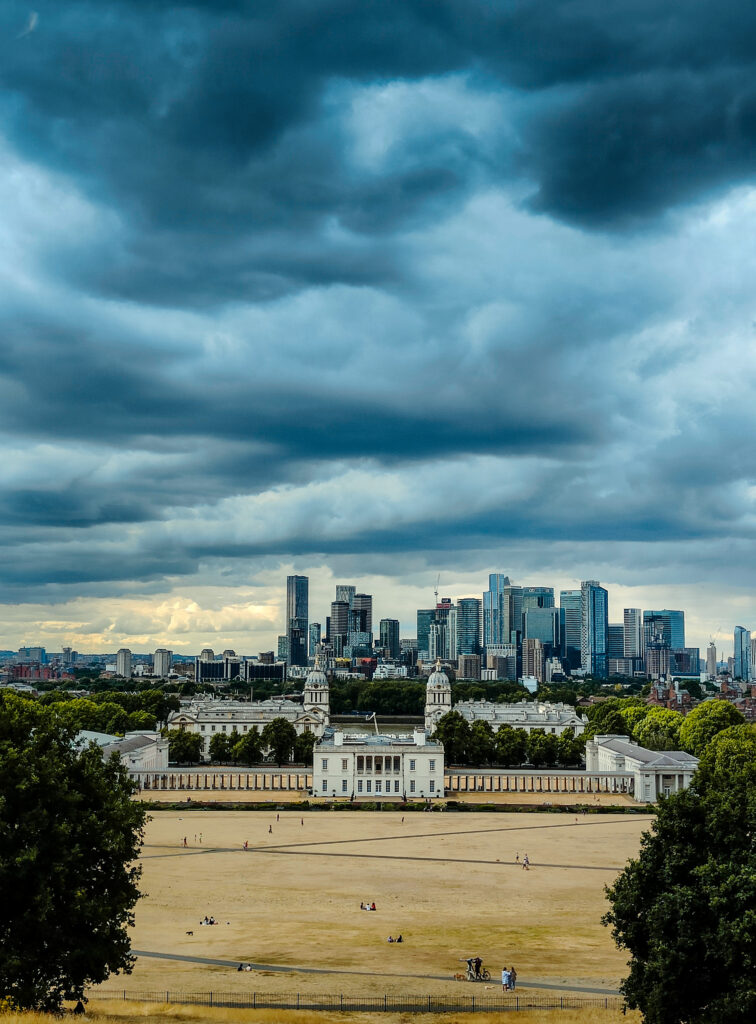 Widok z góry koło obserwatorium w Greenwich. Pochmurne niebo nad wieżowcami w Londynie