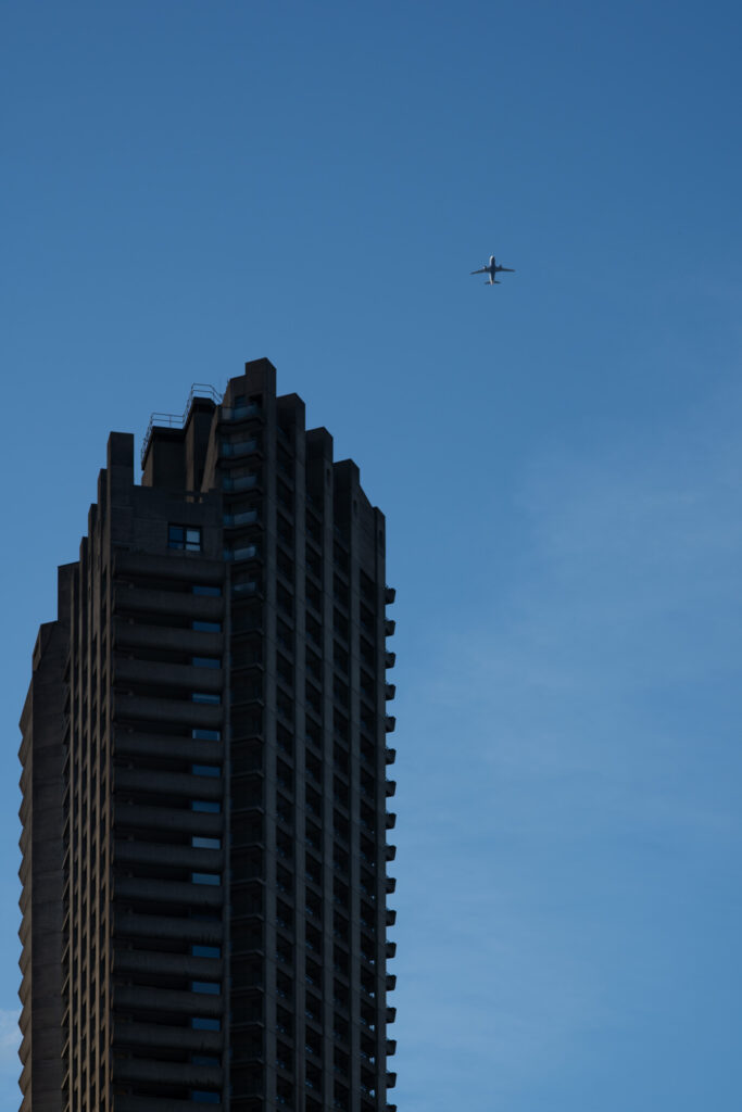 samolot przelatujący nad wieżą barbican