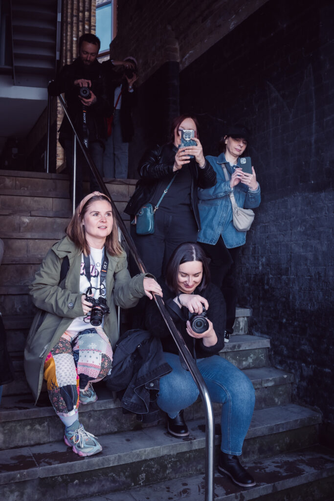 Grupa fotografów na schodach niedaleko Tower Bridge w Londynie
