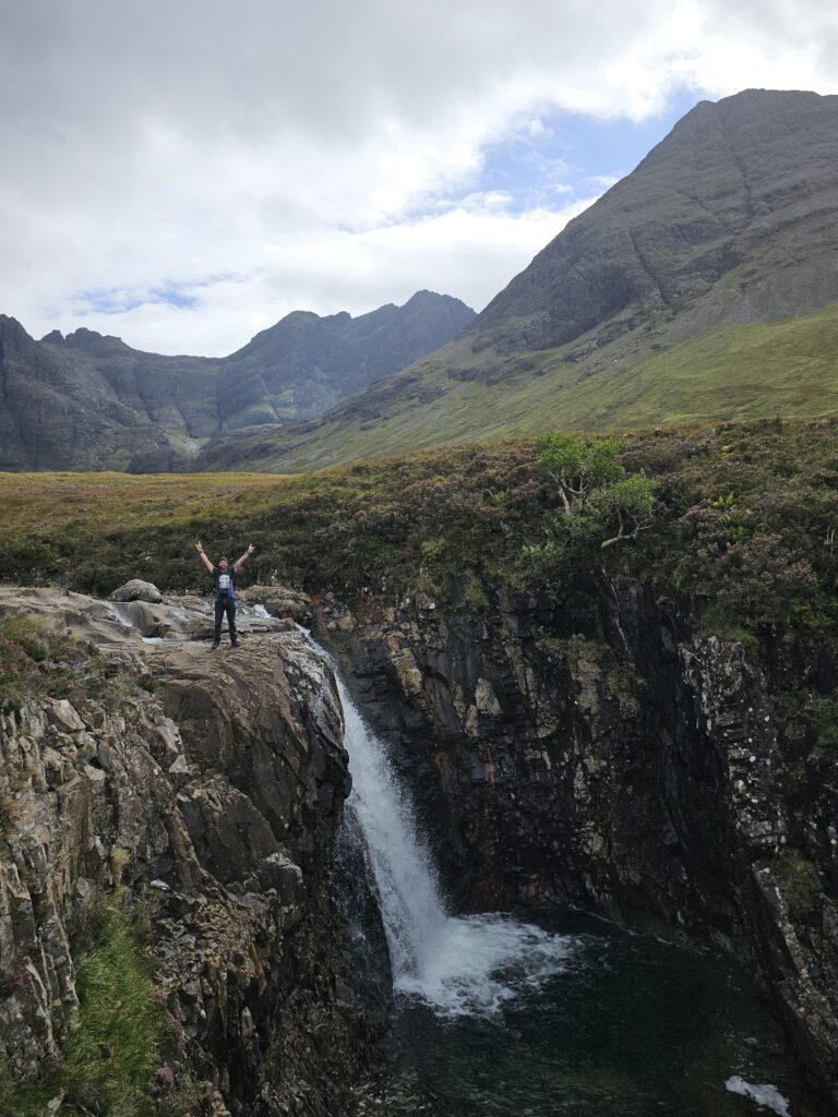 Facet trzymający ręce w górze to ja w Fairy Pools na Isle of Skye