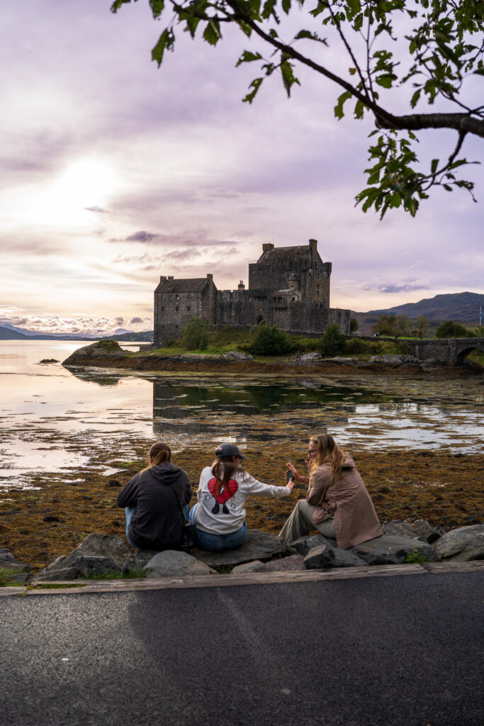 Zamek Eilean Donan o zachodzie słońca z rodziną podziwiającą widok - Szkocja, highland
